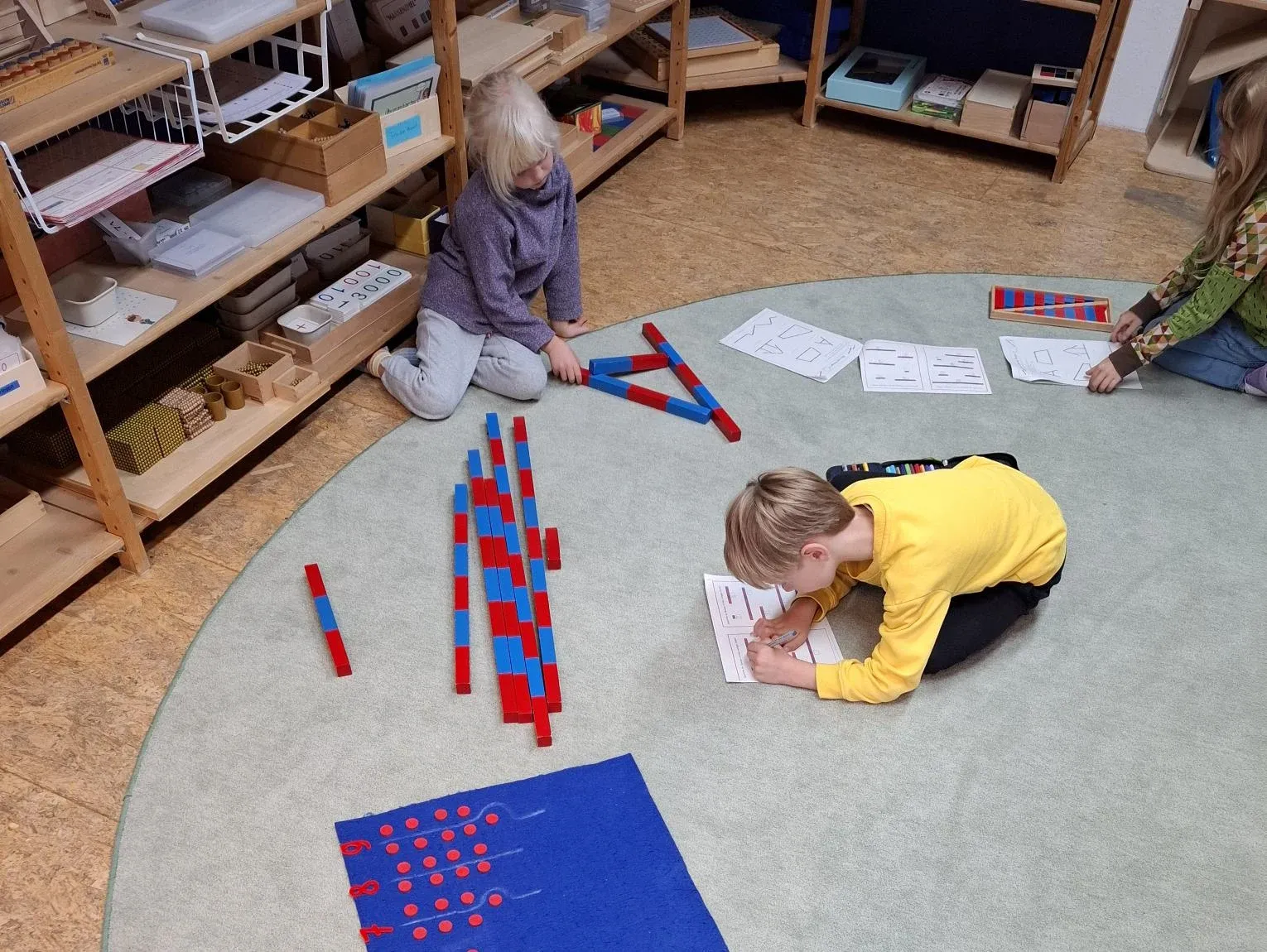 Kinder arbeiten gemeinsam mit Montessori-Mathematikmaterialien