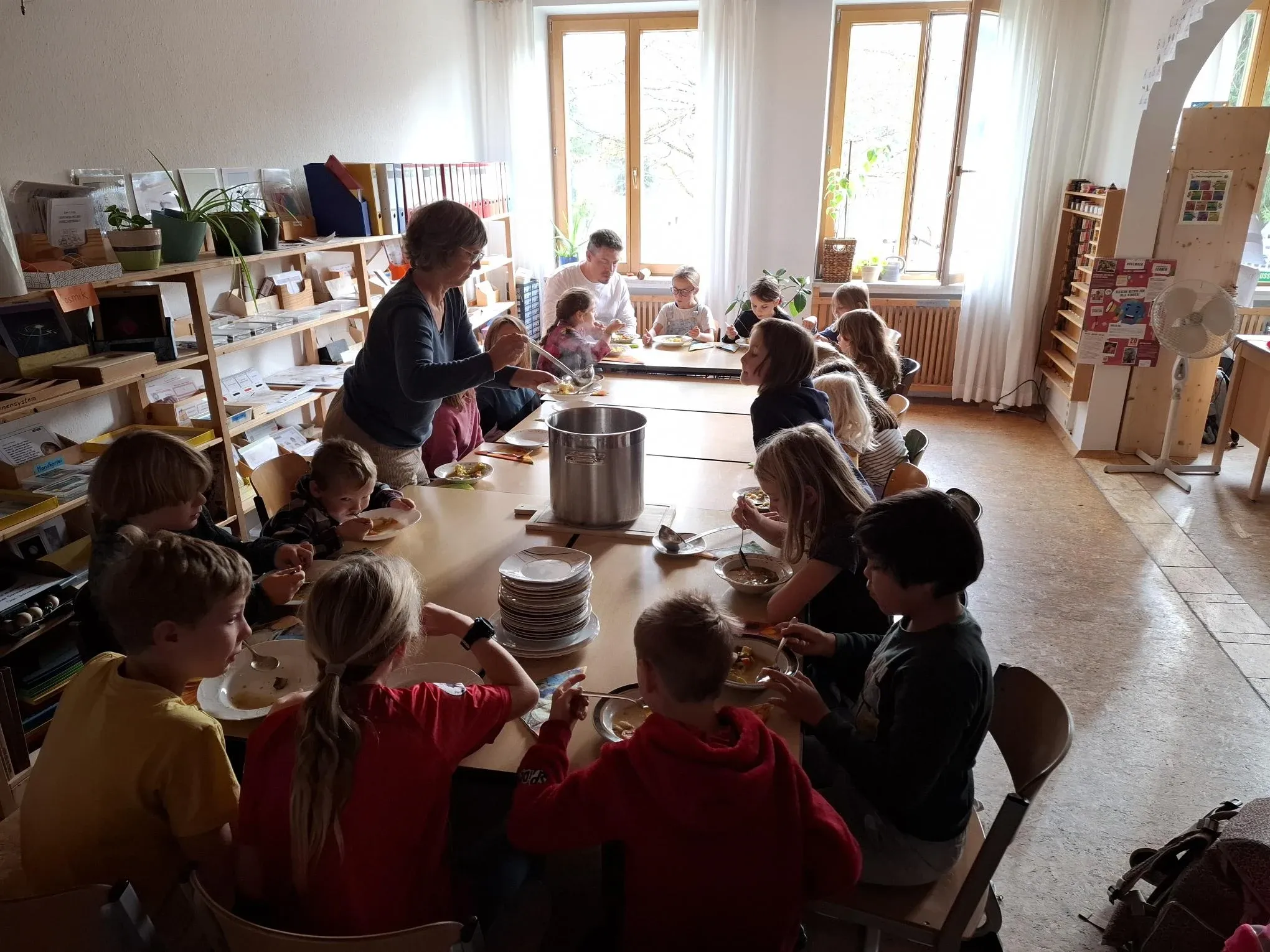 Kinder und Erwachsene essen gemeinsam zu Mittag
