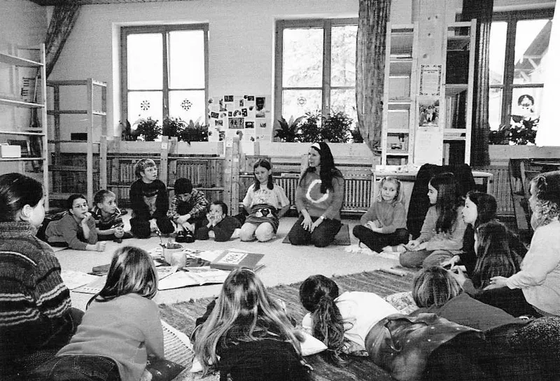 Kinder und Erwachsene in einem Klassenraum der jungen Montessori-Schule